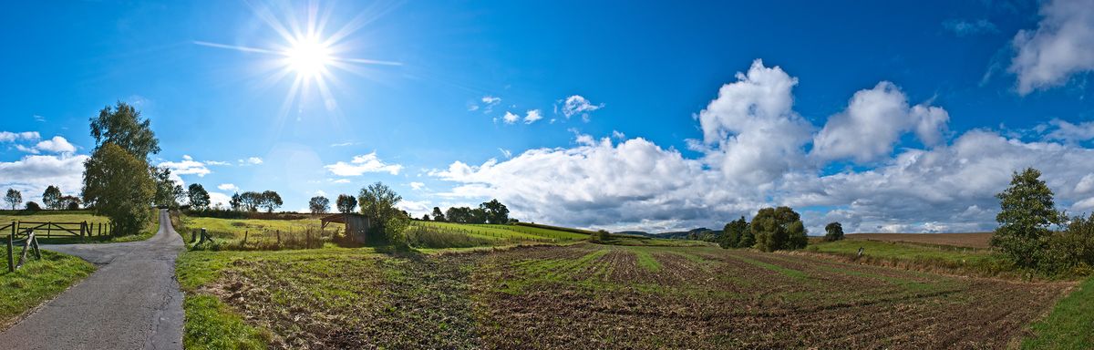 Durch eine kleine Blende habe ich die Sonne bei diesem Panorama zum strahlen gebracht. Dieses Foto entstand freihand in den Felden des Weserberglands in Hessen.